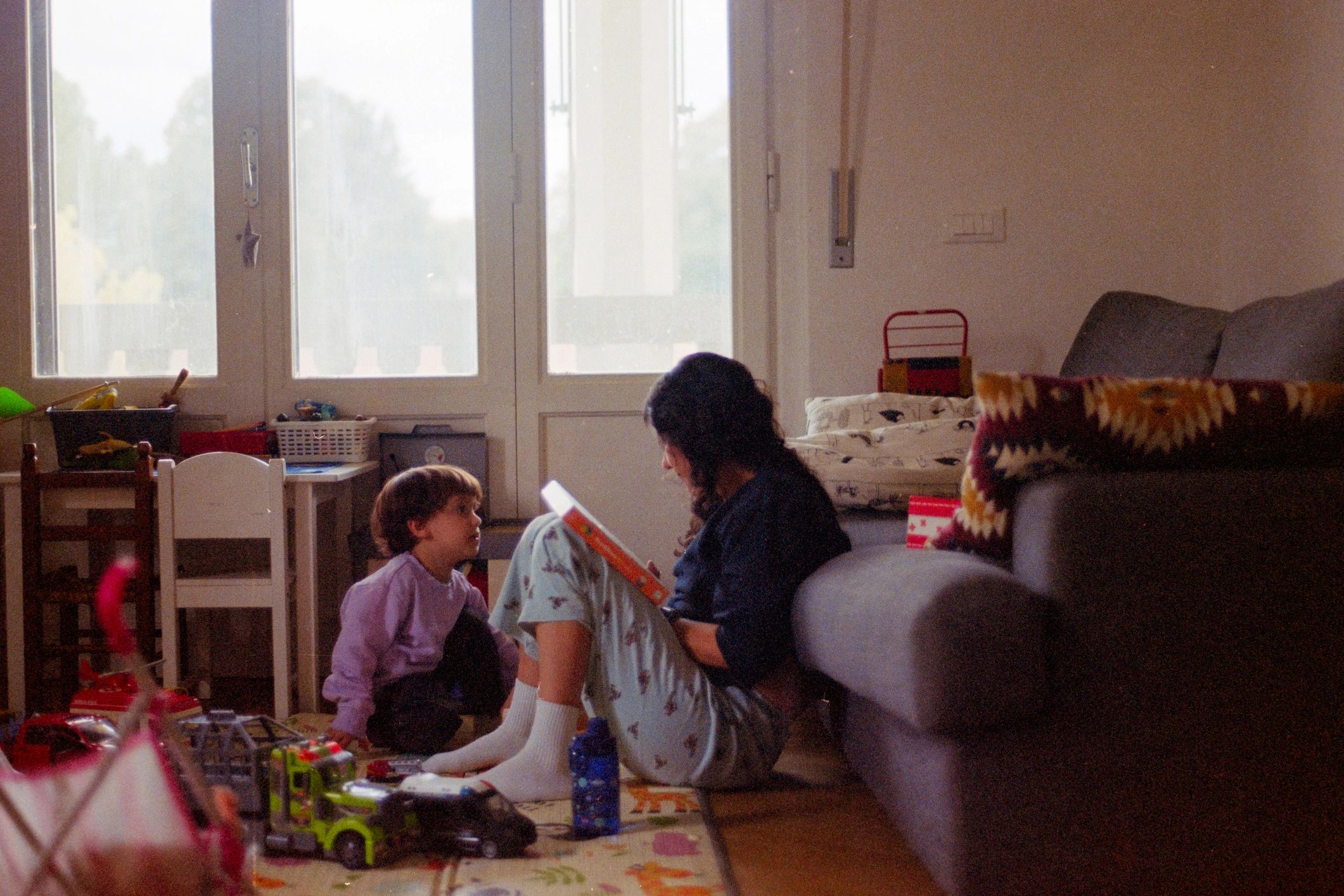 Parent reading with child on the floor at home